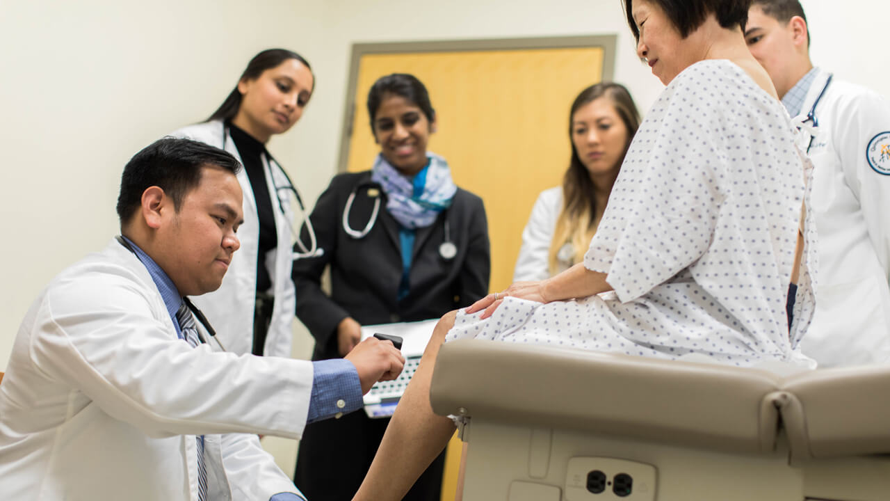 medical students preforming an exam on a standardized patient