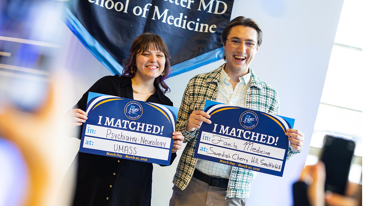 Two students holding up their match signs on Match Day