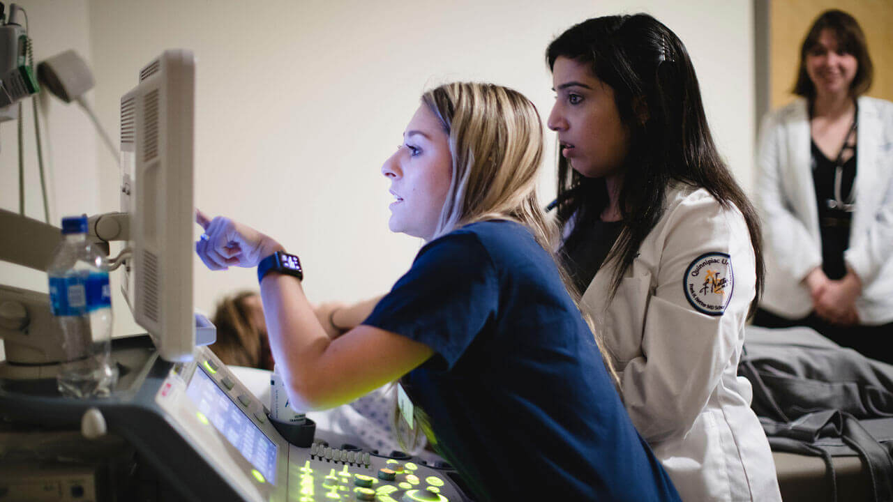 A student demonstrates how to use the cardiac ultrasound to a group of medical students